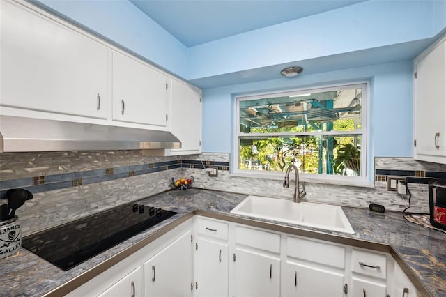 kitchen featuring sink, decorative backsplash, and white cabinets