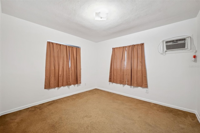 unfurnished room featuring an AC wall unit and carpet flooring