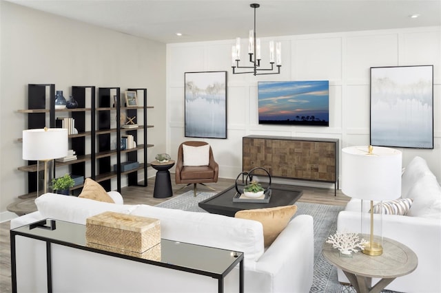 12458 49th St E, Parrish, FL 34219 - living area with wood finished floors, a chandelier, recessed lighting, and a decorative wall