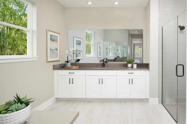 bathroom with vanity and a shower with door