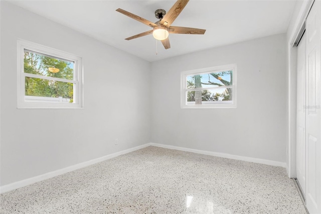 spare room with ceiling fan and a wealth of natural light