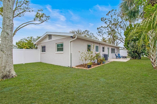 back of house with central AC unit, a patio area, and a lawn