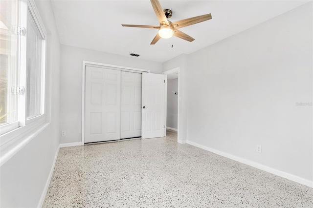 unfurnished bedroom with ceiling fan and a closet