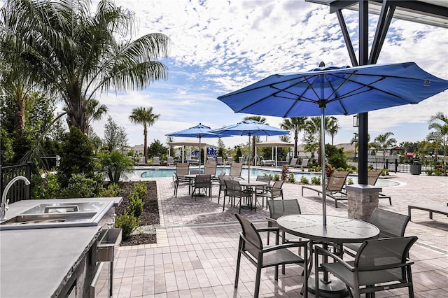 view of patio / terrace with a wet bar and a community pool