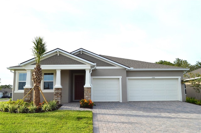 12404 52th St E, Parrish, FL 34219 - craftsman-style home with decorative driveway, an attached garage, stucco siding, and stone siding