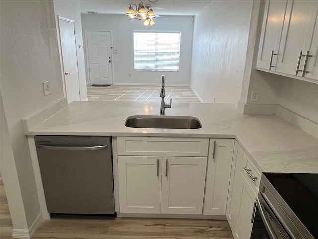 kitchen featuring light stone countertops, stainless steel appliances, sink, light hardwood / wood-style flooring, and white cabinets