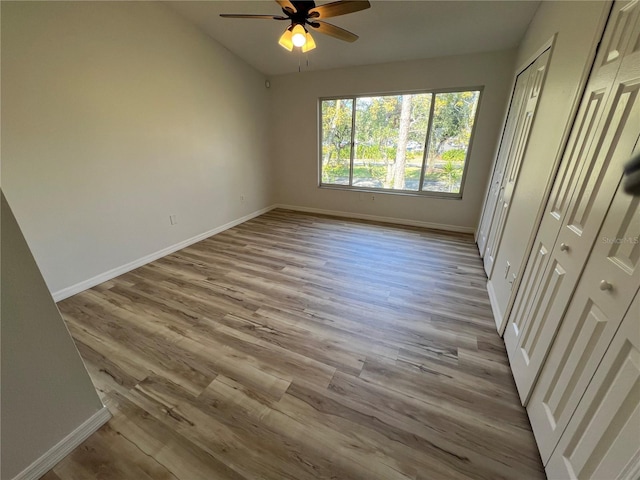 unfurnished bedroom with ceiling fan and light wood-type flooring