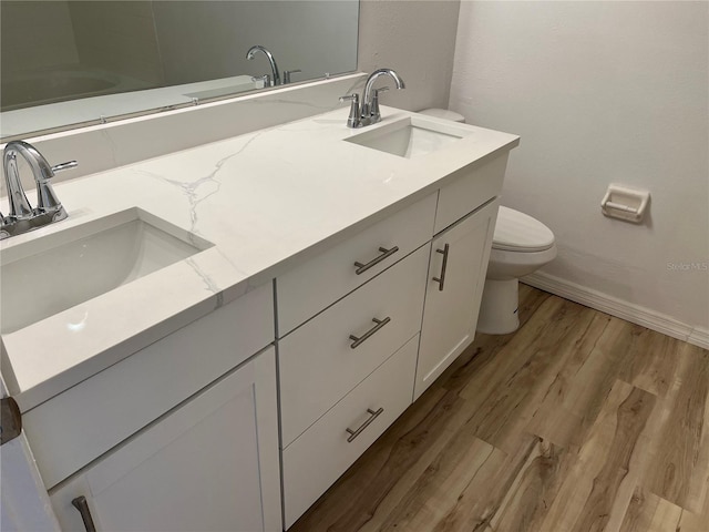 bathroom with vanity, toilet, and wood-type flooring