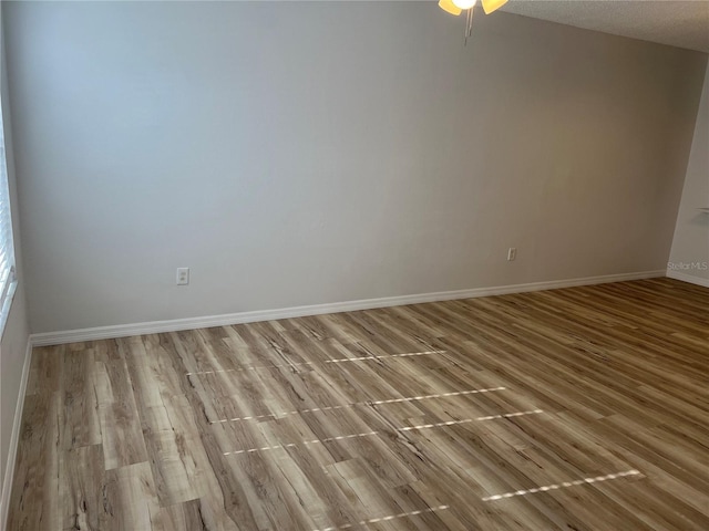 empty room with a textured ceiling and light wood-type flooring