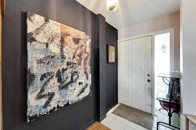 tiled entrance foyer featuring a textured ceiling