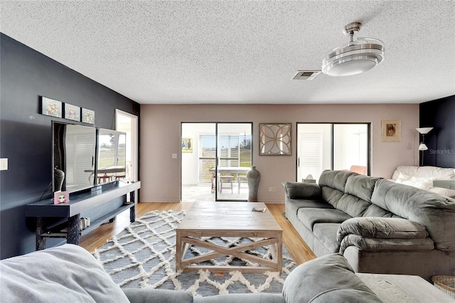 living room featuring a textured ceiling and light wood-type flooring