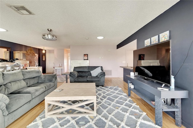 living room featuring light hardwood / wood-style floors and a textured ceiling