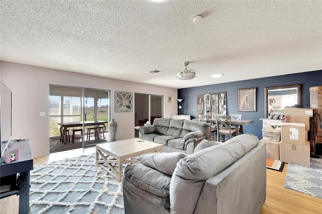 living room featuring light hardwood / wood-style floors and a textured ceiling