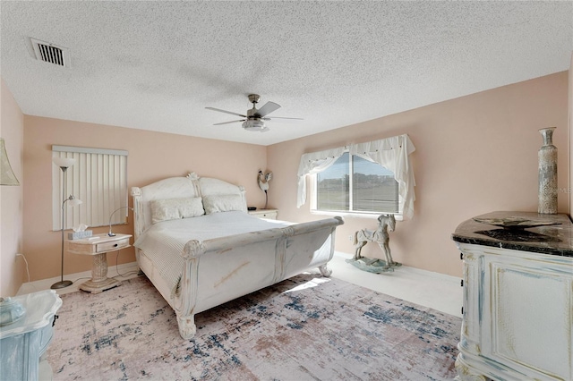 bedroom with ceiling fan and a textured ceiling