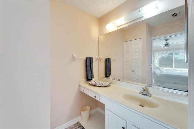 bathroom with vanity, ceiling fan, tile patterned flooring, and a textured ceiling