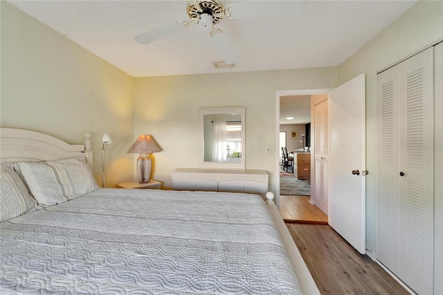 bedroom featuring ceiling fan, a closet, and light wood-type flooring