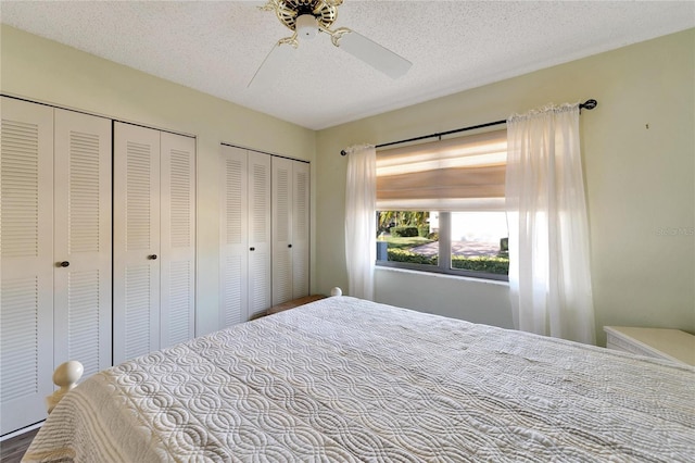 bedroom featuring multiple closets, ceiling fan, and a textured ceiling