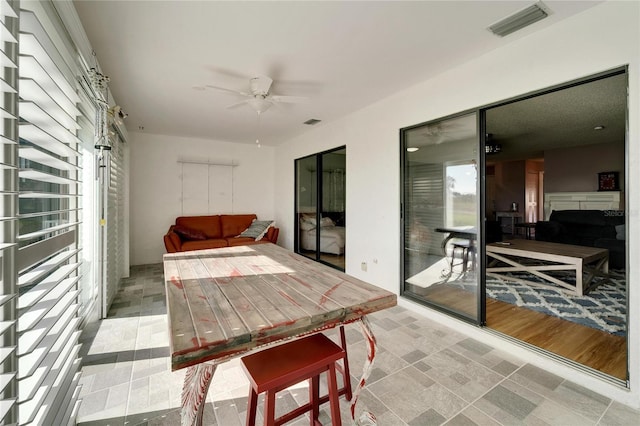 sunroom / solarium featuring ceiling fan