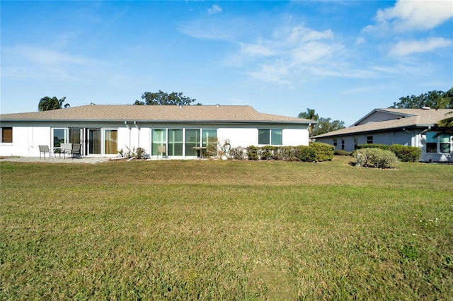 rear view of house with a yard and a patio