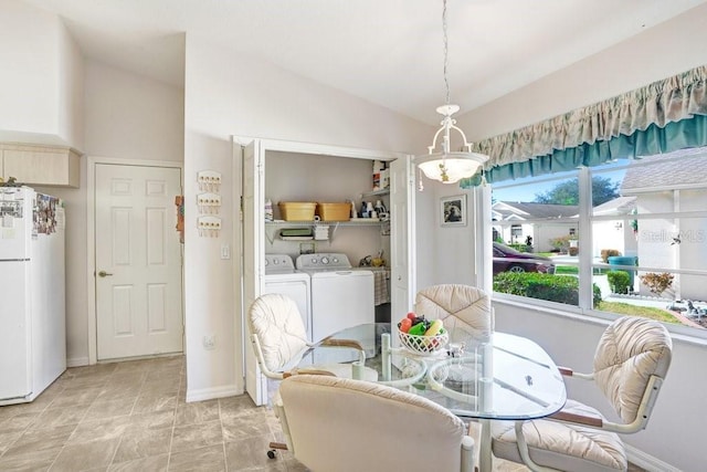 dining area with washer and dryer, lofted ceiling, and a notable chandelier