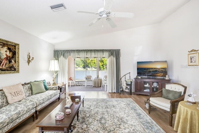 living room with light hardwood / wood-style floors, ceiling fan, and lofted ceiling