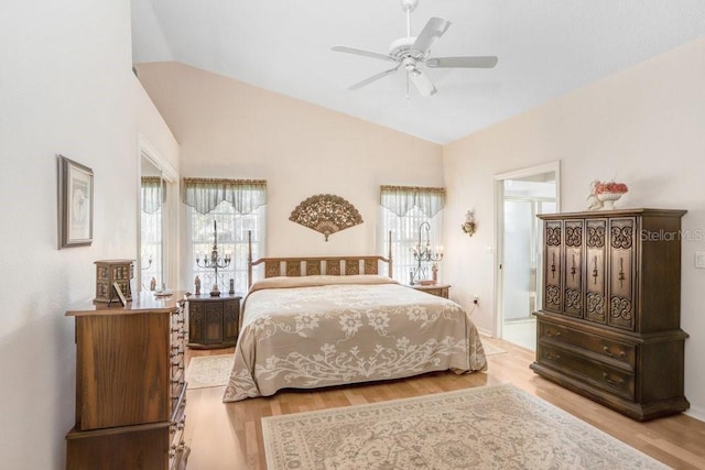 bedroom featuring ceiling fan, light wood-type flooring, and vaulted ceiling