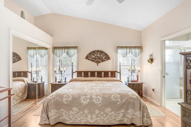 bedroom featuring multiple windows, ceiling fan, vaulted ceiling, and light wood-type flooring