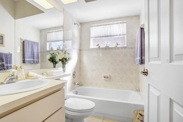 full bathroom with tile patterned floors, vanity, tiled shower / bath combo, and toilet