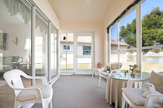 sunroom featuring a water view