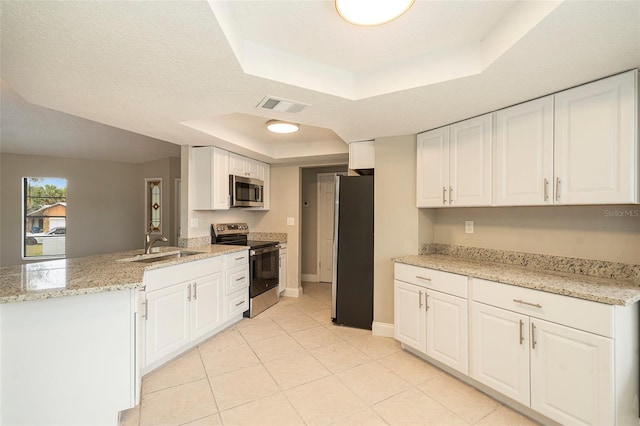 kitchen featuring white cabinetry, kitchen peninsula, stainless steel appliances, and a tray ceiling