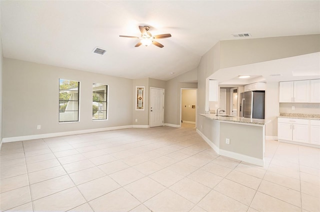 unfurnished living room with sink, ceiling fan, lofted ceiling, and light tile patterned flooring