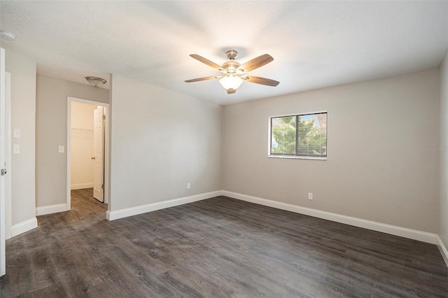 spare room featuring ceiling fan and dark hardwood / wood-style flooring