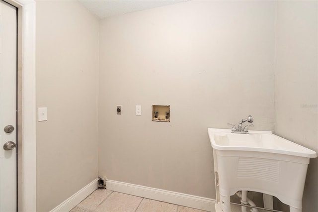 washroom featuring electric dryer hookup, sink, light tile patterned floors, and washer hookup