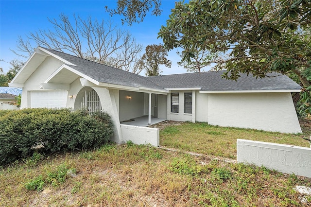 single story home with a front yard and a garage