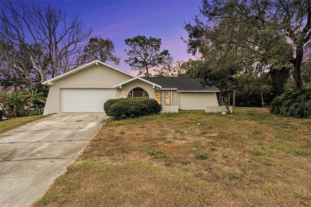 single story home featuring a yard and a garage