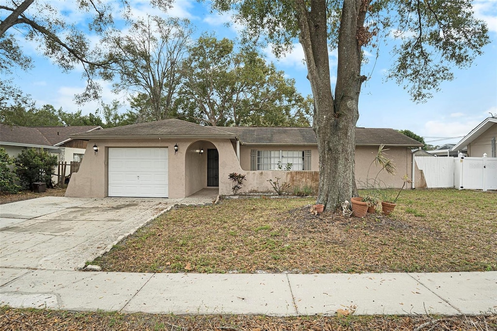 ranch-style home featuring a garage and a front lawn