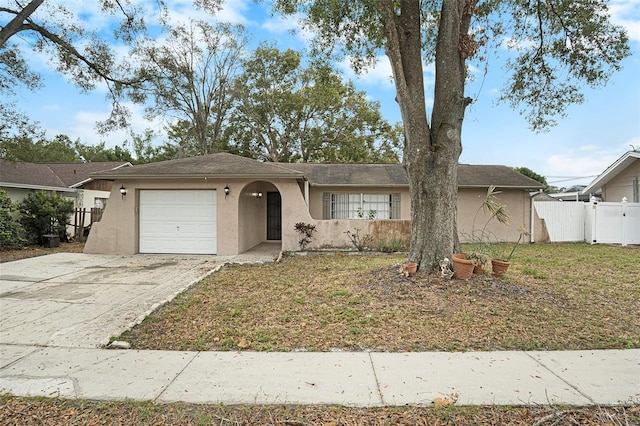 ranch-style home featuring a garage and a front lawn