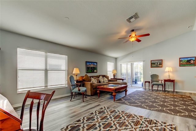 living room with light hardwood / wood-style flooring, ceiling fan, and lofted ceiling