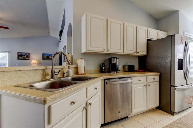 kitchen with sink, vaulted ceiling, ceiling fan, light tile patterned floors, and appliances with stainless steel finishes