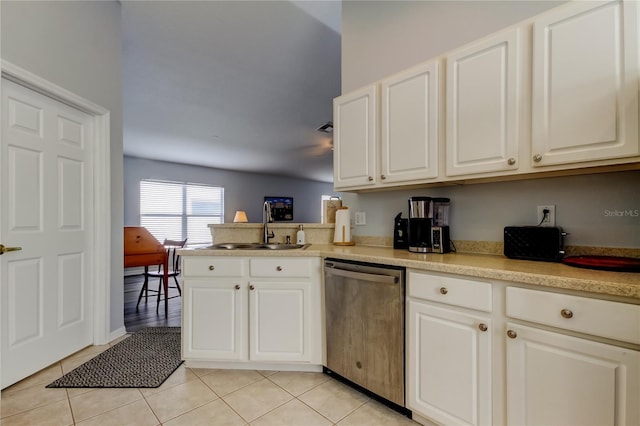 kitchen featuring kitchen peninsula, stainless steel dishwasher, sink, light tile patterned floors, and white cabinets