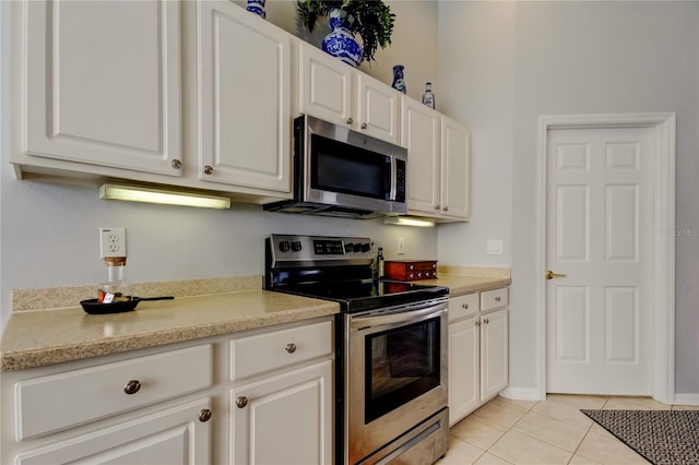 kitchen featuring white cabinets, light tile patterned floors, and appliances with stainless steel finishes