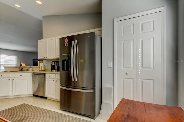 kitchen with white cabinets, appliances with stainless steel finishes, light tile patterned floors, and sink