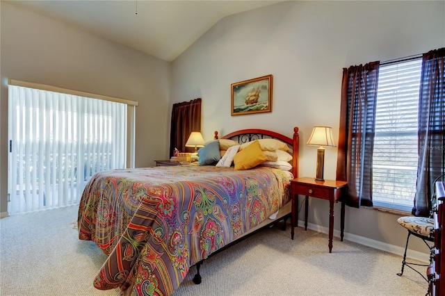 carpeted bedroom featuring access to exterior, multiple windows, and vaulted ceiling