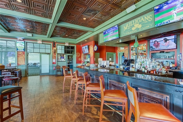 bar featuring dark stone countertops, wood-type flooring, and coffered ceiling