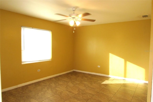 empty room featuring ceiling fan and a healthy amount of sunlight