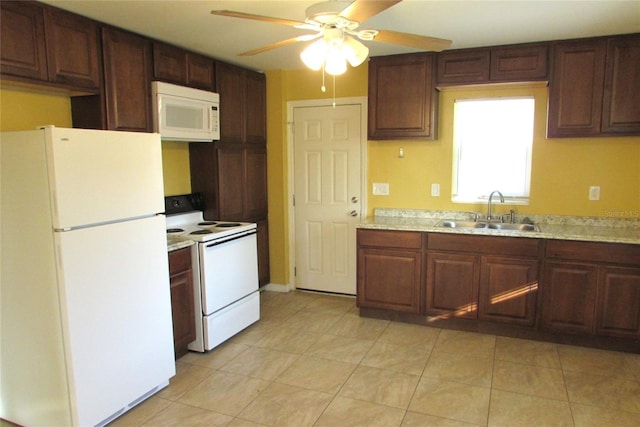 kitchen with ceiling fan, light stone counters, white appliances, and sink