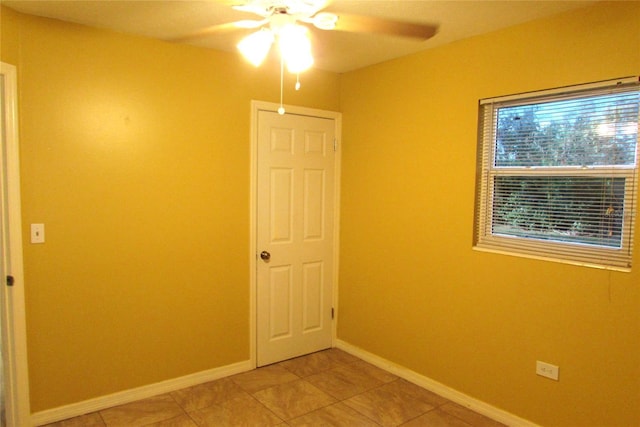 empty room featuring tile patterned flooring and ceiling fan