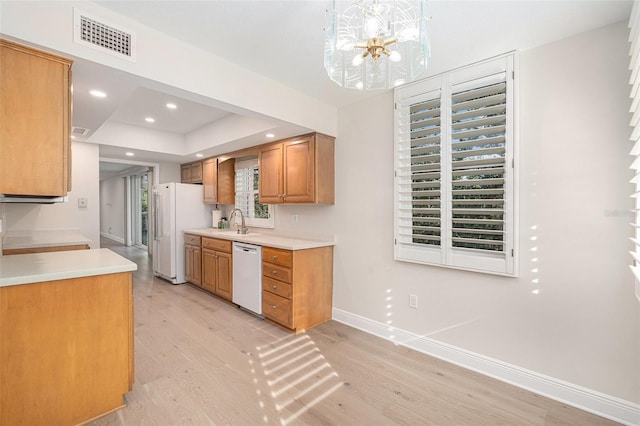 kitchen featuring decorative light fixtures, white appliances, light hardwood / wood-style floors, and a healthy amount of sunlight