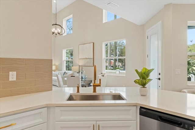 kitchen with sink, white cabinets, stainless steel dishwasher, and decorative light fixtures