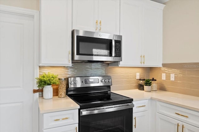 kitchen featuring white cabinets, appliances with stainless steel finishes, and tasteful backsplash